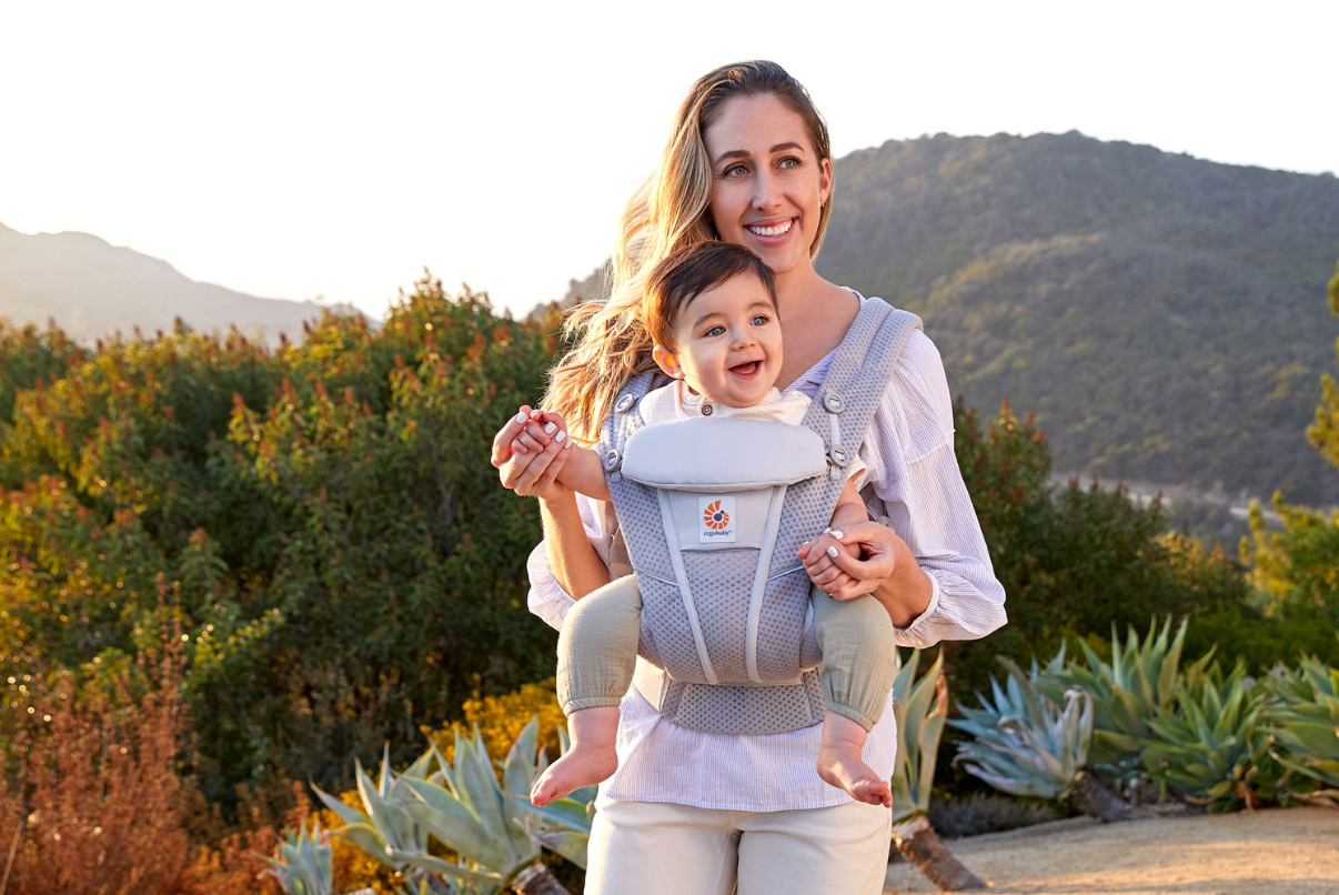 Une maman à l'extérieur avec un bébé dans le porte-bébé Omni Breeze d'Ergobaby
